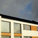 Staande felsplaat PD-510-S Vlak Gitzwart op een modern gebouw met grote ramen, plaatsing