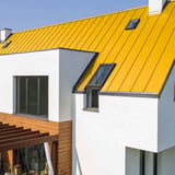 Huis met felsdakpaneel PD-510-S Vlak dak in Koolzaadgeel, detailaanzicht met dakramen