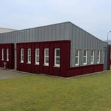Bedrijfsgebouw met gevelbekleding van golfplaat 18/1064 in Wijnrood (RAL 3005), toepassingsvoorbeeld