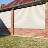 Golfplaat 18/1064, zuiverwit, als wandbekleding tussen rode bakstenen pilaren aan huis