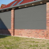 Golfplaat 18/1064 aluminium 0,70 mm, RAL9007, als wandbekleding op een bakstenen huis