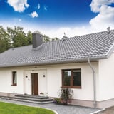 Woning met zilver-metallic Niagara dakgoten en afvoerbuizen gemonteerd aan het dak