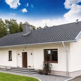 Witte woning met verzinkte dakgoten en regenpijpen van Niagara, compleet systeem