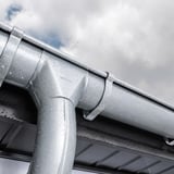 Detail van verzinkte dakgoot en regenpijp van Niagara met waterdruppels