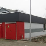 Gebouw met donkergrijze HPL plaat dakrandbekleding boven rode en grijze bakstenen muren