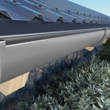 Grafiet PVC dakgoot gemonteerd aan het dak van een gebouw met houten spanten