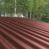 Bruine gerecyclede kunststof profielplaat ReWell 94/34 op een dak met zichtbare bevestigingen