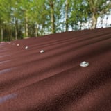 Detail van de bevestigingsschroeven op de bruine gerecyclede kunststof profielplaat