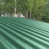 Groene profielplaten ReWell 94/34 op een dak met bomen op de achtergrond