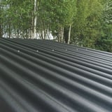 Zwarte ReWell profielplaten 94/34 op een dak met zichtbare bevestigingsschroeven