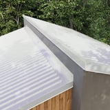 Wandafsluiting lichtgrijs RAL 7035 op de daknok van een gebouw, totaalbeeld van de installatie