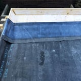 Plaatsing van de dakbedekking met BlueTek oppervlaklijm op houten dak, detail van de dakrand