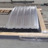 Gebogen lichtplaat van aluminium, blank, met profielstructuur op houten pallet