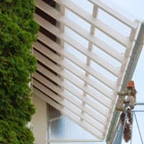 Gelegde PET damwandplaat 70/18 als terrasoverkapping met houten spanten