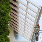 Helder PET damwandplaten 76/18 als dak van een terrasoverkapping met houten constructie