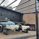 Zitgedeelte onder een terrasoverkapping met heldere polycarbonaat lichtplaten
