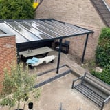 Moderne terrasoverkapping met heldere polycarbonaat lichtplaten aan een huis