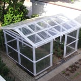 Kas met dak en zijwanden van heldere polycarbonaat golfplaten