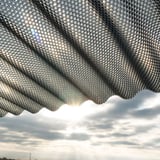 Onderaanzicht van de polycarbonaat golfplaat 76/18, 2,80 mm, brons, met honingraatstructuur en zonlicht