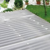 Gelegde heldere polycarbonaat golfplaten met honingraatstructuur op een dak met bevestigingsdoppen