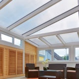 Helder polycarbonaat lichtplaat 25 mm als dakbedekking van een serre, interieur met meubels
