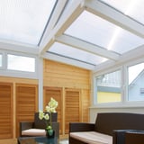 Helder polycarbonaat lichtplaat 25 mm als dak van een serre, interieur met houten wanden