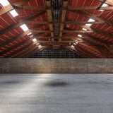 Interieur van een grote hal met houten dakconstructie en terracotta golfplaten