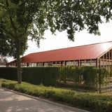 Terracotta golfplaten op een groot dak van een gebouw met houten constructie