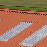 Dak met terracotta golfplaten en transparante lichtplaten, close-up