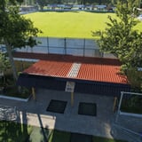 Bovenaanzicht van overkapping met terracotta golfplaten dak en lichtplaat