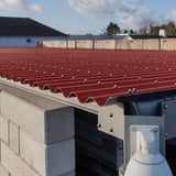 Detail van terracotta golfplaten dak met bevestigingsschroeven op een constructie