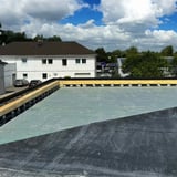 Plat dak met randfixatiestrip EPDM zwart op houten onderconstructie, totaalbeeld