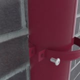 Detail van kersrode regenpijpbeugel om een regenpijp, met bevestigingsschroef