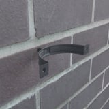 Niagara regenpijpbeugel, antracietgrijs, gemonteerd met schroef aan een bakstenen muur