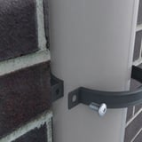 Niagara regenpijpbeugel, antracietgrijs, gemonteerd rond een regenpijp aan een bakstenen muur