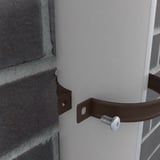 Detail van een chocoladebruine regenpijpbeugel die een witte regenpijp aan een bakstenen muur bevestigt
