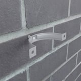 Niagara regenpijpbeugel van staal, zilver-metallic (RAL 9006) gemonteerd aan een bakstenen muur