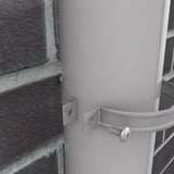 Detail van grijs aluminiumkleurige valbuisklem met schroef, gemonteerd op regenpijp en bakstenen muur