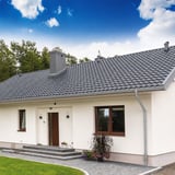 Huis met gemonteerde dakgoten en regenpijp van staal, grijs aluminiumkleurig (RAL9007)