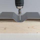 Montage van een RVS schroef in diepte van een damwandplaat op hout, schroevendraaier geplaatst