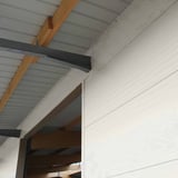 Sandwichpaneel Wall 1100 80, Grijswit, detail van de wandbekleding onder een dakconstructie