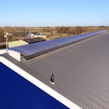 Lange rij gebogen lichtplaten van helder polycarbonaat op een industrieel dak