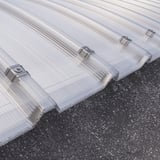 Detailweergave van de gebogen polycarbonaat lichtplaat 20 mm, helder, met bevestigingsklemmen op het dak