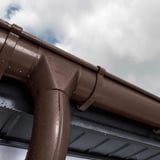 Detail van chocoladebruine stalen dakgoot van Niagara met waterdruppels na regen