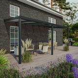 Terrasoverkapping 16 mm, RAL 7016, gemonteerd aan een huis met donkere bakstenen muur