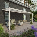 Terrasoverkapping RAL 9001, 16 mm, aan een huis met donkere bakstenen muur, uitzicht op terras met meubels