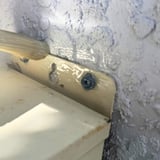 Transparant vloeibaar kunststof wordt met kwast op metalen hoekprofiel met schroeven aangebracht