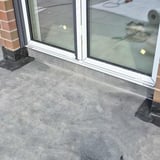 Plaatsing van het zwarte DACHPROTECT vorm- en afdekband van EPDM bij een terrasdeur