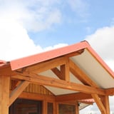 Houten dakconstructie met terracotta windveren en dakbedekking, buitenaanzicht