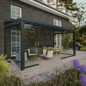 Glazen schuifdeuren voorzijde RAL 7016 aan een huis met terras en tuin